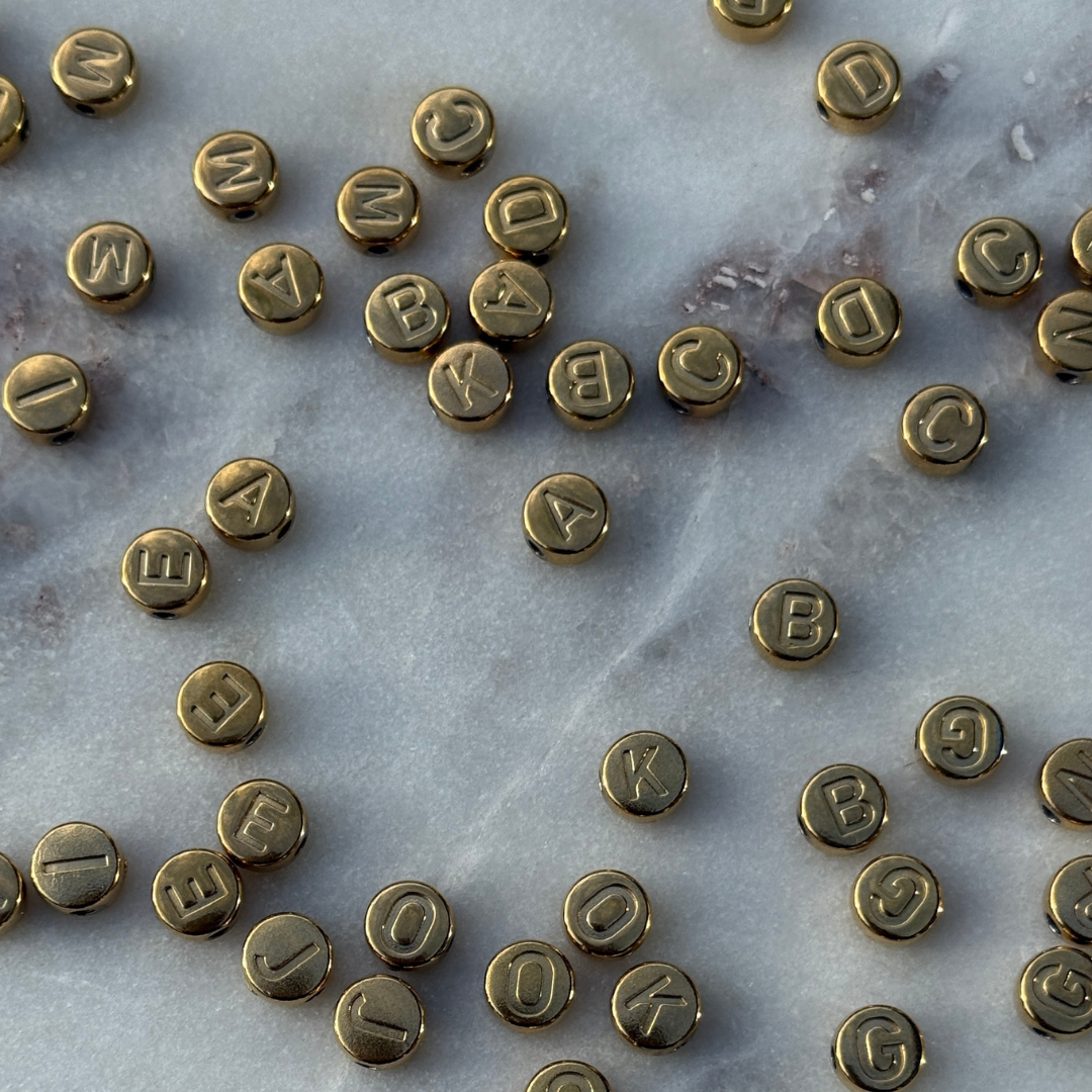 Goldfarbene Buchstabenperlen aus Edelstahl zur Personalisierung von Schmuck