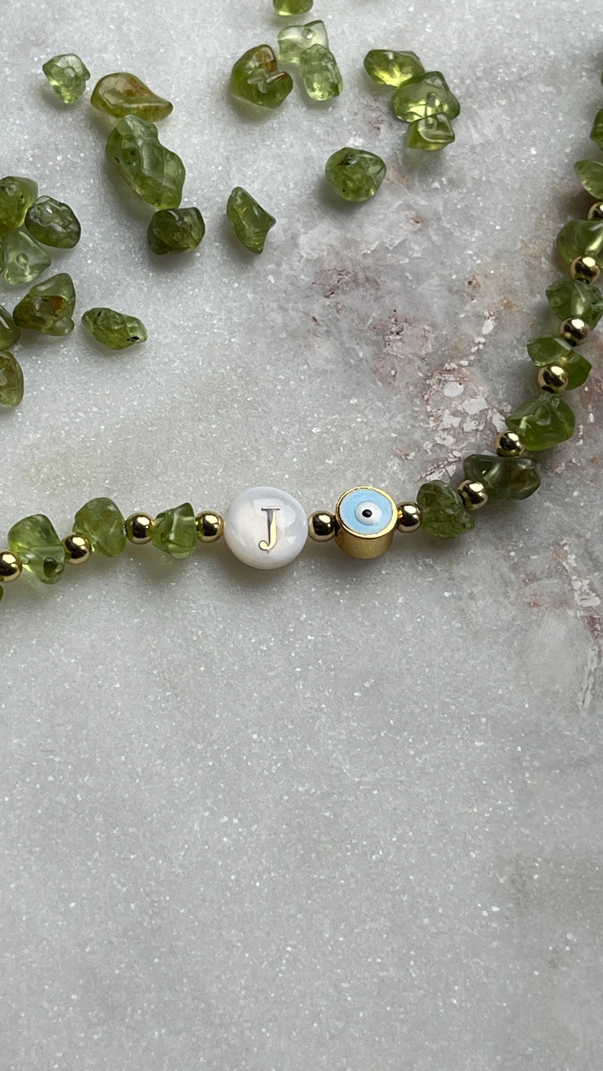 Personalisiertes grünes Edelsteinarmband mit Buchstabenperle beim Schmuckworkshop in Köln